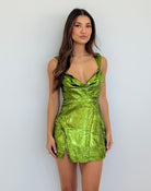 Woman wearing a green metallic dress against a white background