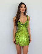 Woman wearing a green metallic dress against a white background